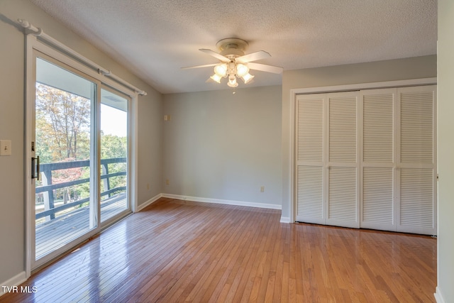 unfurnished bedroom featuring access to exterior, a closet, a textured ceiling, light hardwood / wood-style floors, and ceiling fan