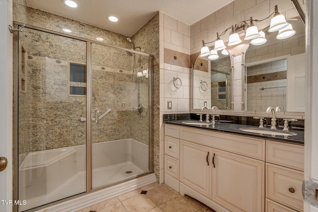 bathroom with tile patterned floors, vanity, tile walls, a textured ceiling, and walk in shower