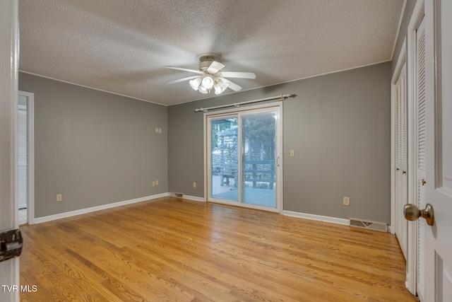 unfurnished room with light hardwood / wood-style floors, a textured ceiling, and ceiling fan