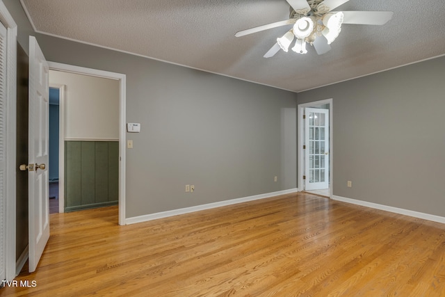 spare room featuring light hardwood / wood-style flooring, a textured ceiling, and ceiling fan