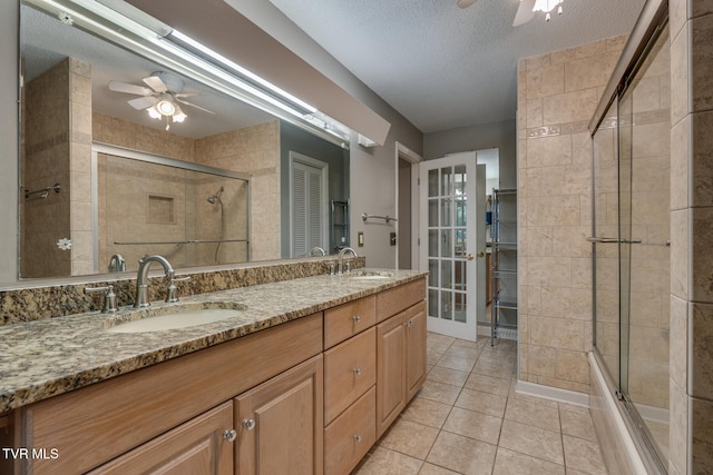 bathroom featuring vanity, ceiling fan, a textured ceiling, and tile patterned flooring