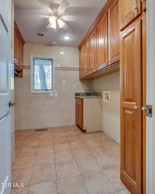 clothes washing area featuring hookup for a washing machine, ceiling fan, and cabinets