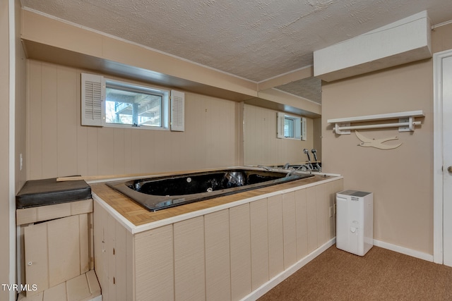 bathroom featuring a textured ceiling, wooden walls, and a washtub