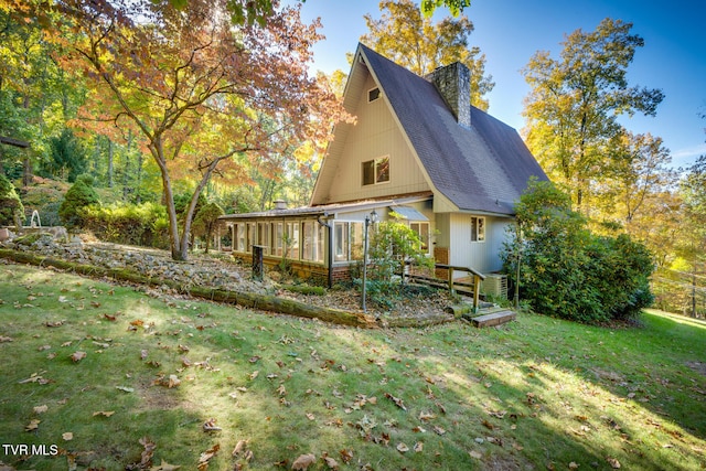 view of home's exterior featuring a yard and a sunroom