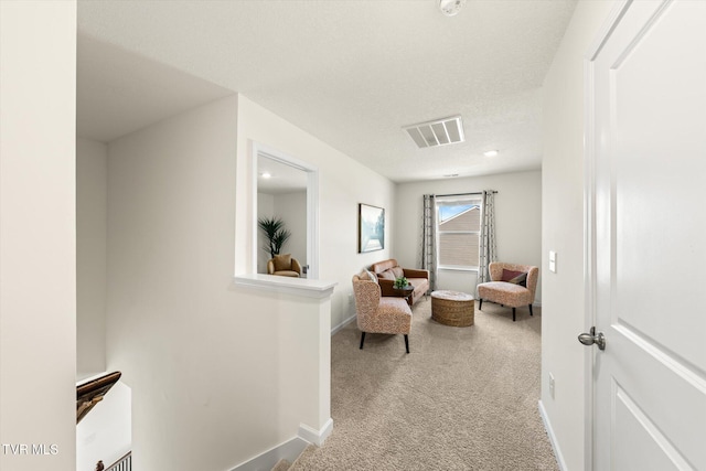 living area with light carpet and a textured ceiling