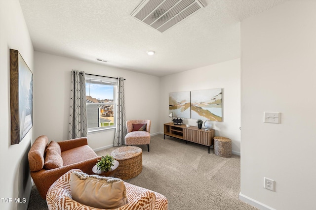 living area featuring light carpet and a textured ceiling