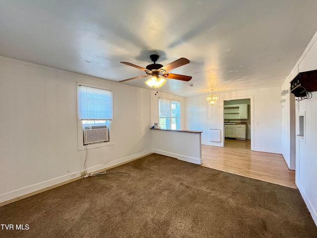 empty room featuring cooling unit, ceiling fan with notable chandelier, and carpet