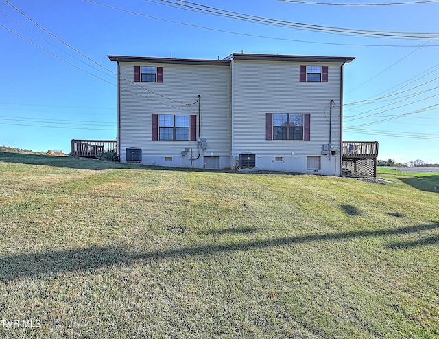 rear view of property with central AC, a deck, and a yard