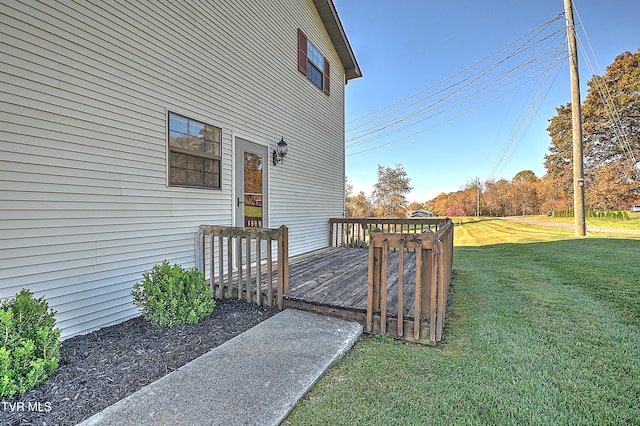 view of side of property featuring a wooden deck and a lawn