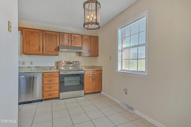 kitchen with stainless steel appliances, light tile patterned flooring, a notable chandelier, decorative light fixtures, and a textured ceiling