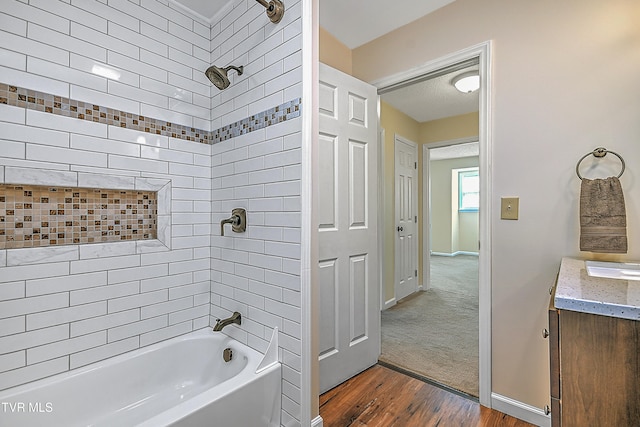 bathroom with vanity, tiled shower / bath combo, and hardwood / wood-style floors