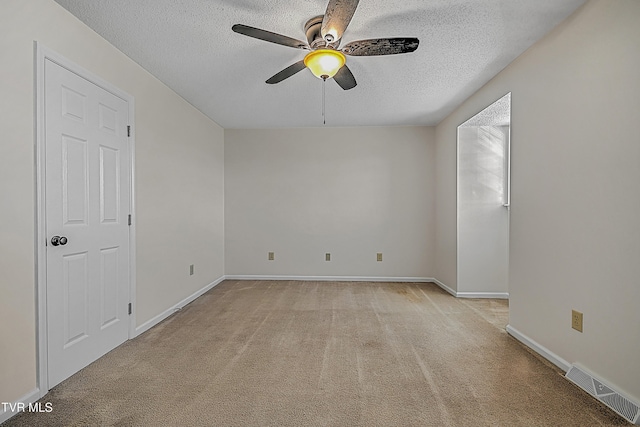 unfurnished room featuring ceiling fan, light carpet, and a textured ceiling