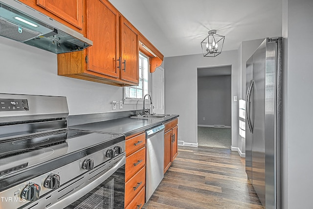 kitchen with dark hardwood / wood-style floors, hanging light fixtures, stainless steel appliances, sink, and an inviting chandelier