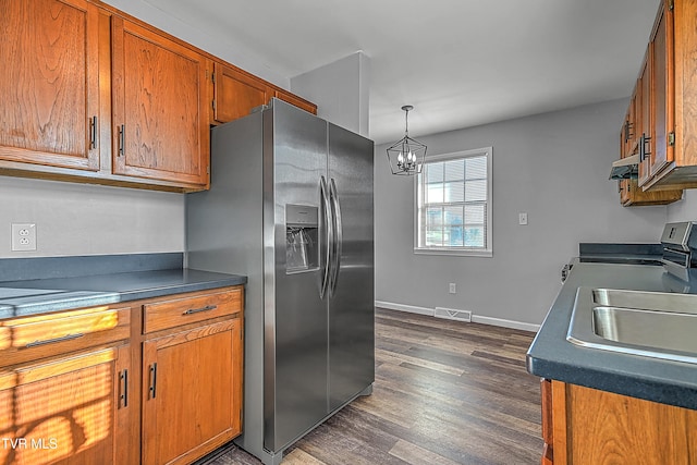 kitchen with sink, dark hardwood / wood-style flooring, hanging light fixtures, stainless steel fridge, and a chandelier