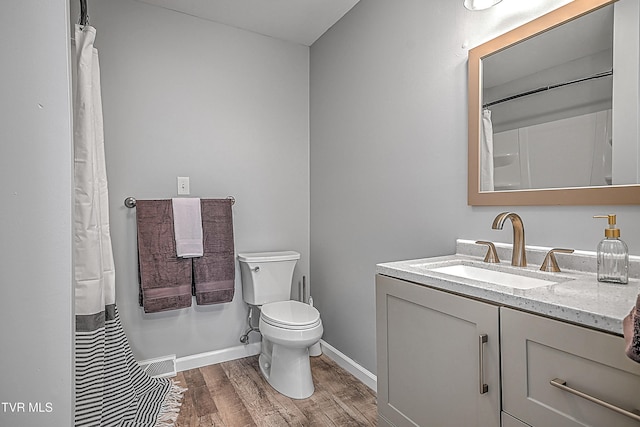 bathroom with vanity, hardwood / wood-style flooring, and toilet