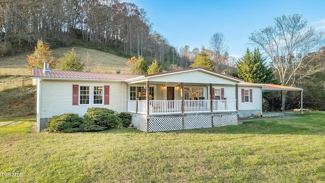 view of front of home with a carport, a front lawn, and a porch