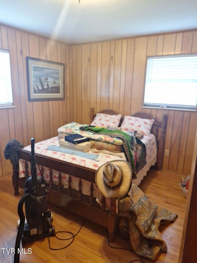 bedroom featuring wooden walls and light wood-type flooring