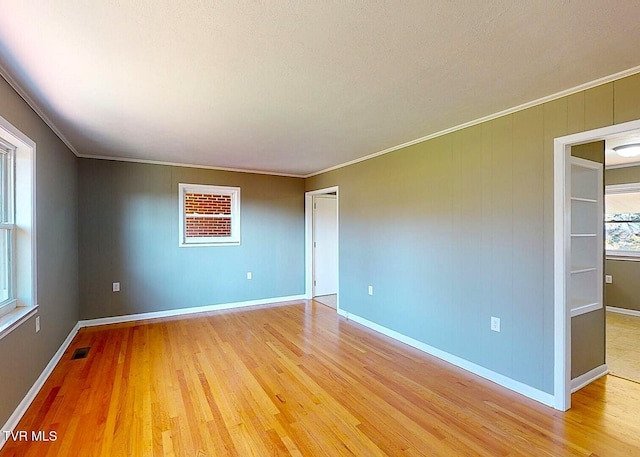 unfurnished room featuring crown molding and light hardwood / wood-style flooring