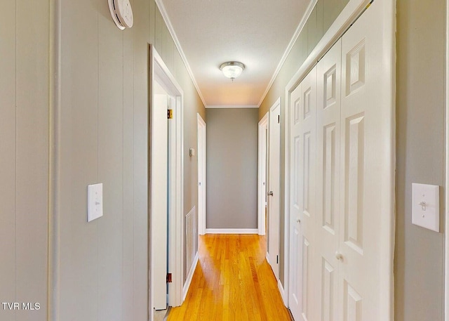 hall featuring crown molding and light hardwood / wood-style flooring