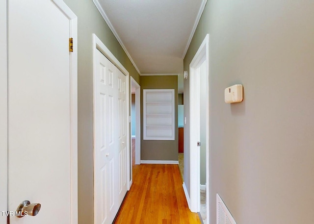 hallway featuring light hardwood / wood-style floors and ornamental molding