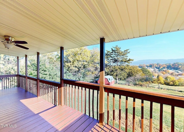 wooden deck with a yard and ceiling fan