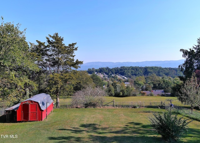 view of yard featuring a rural view, a storage unit, and a mountain view