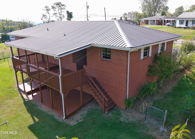 back of property featuring a wooden deck and a yard