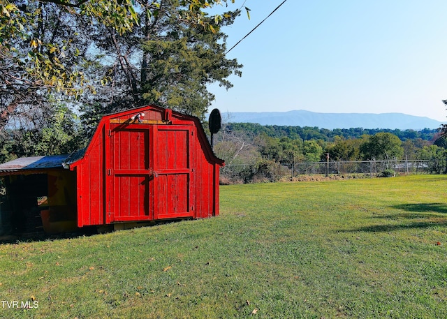 view of outdoor structure featuring a mountain view and a lawn