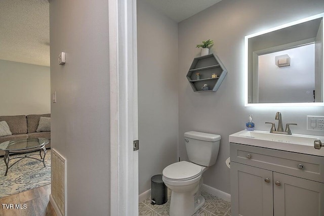 bathroom featuring toilet, baseboards, visible vents, and vanity