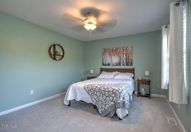 carpeted bedroom featuring visible vents, baseboards, and ceiling fan