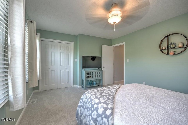 bedroom with carpet flooring, a ceiling fan, baseboards, visible vents, and a closet