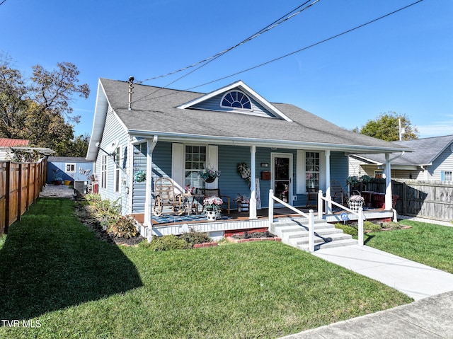 bungalow-style home featuring cooling unit, a front yard, and covered porch