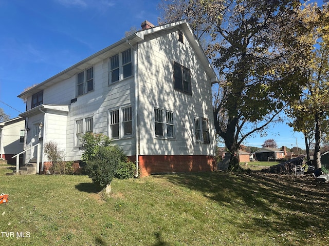 view of side of home with a yard