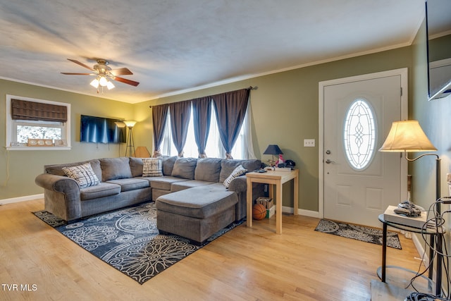 living room featuring hardwood / wood-style flooring, ceiling fan, and crown molding