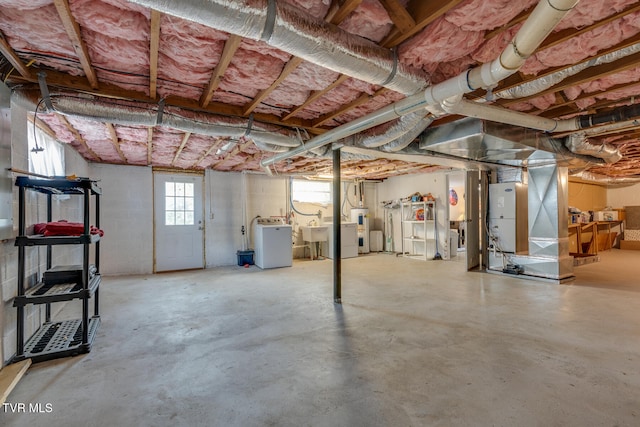 basement featuring electric water heater and sink