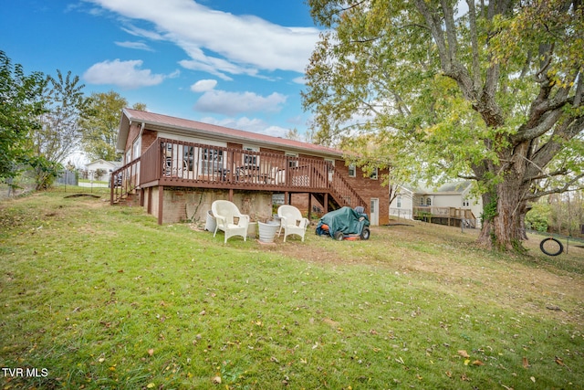 rear view of house featuring a wooden deck and a lawn