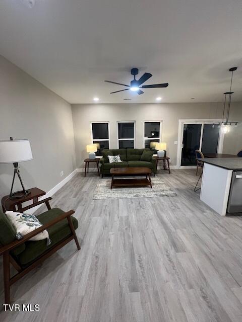 living room featuring light hardwood / wood-style flooring and ceiling fan