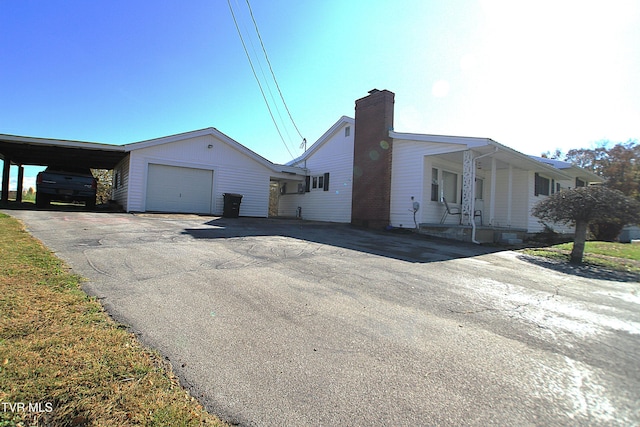 939 Muddy Creek Rd, Piney Flats, TN 37686 - view of side of home with a chimney, driveway, and a garage