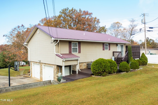 exterior space featuring central AC unit, a garage, and a yard