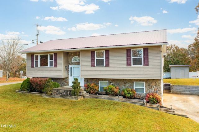 bi-level home featuring a front lawn and a storage shed