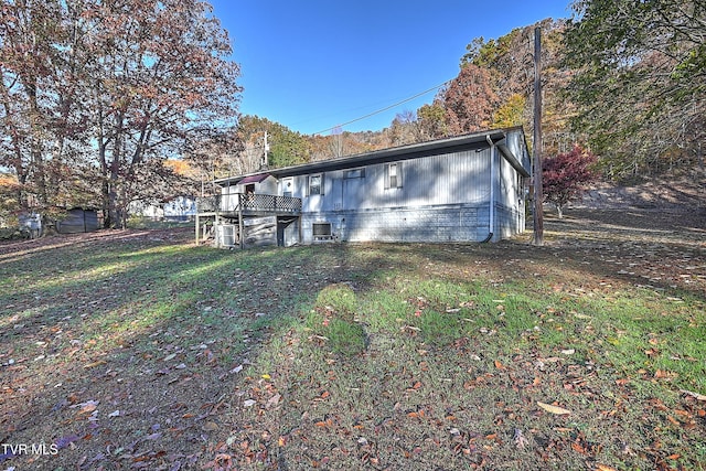 back of house with a lawn and a wooden deck