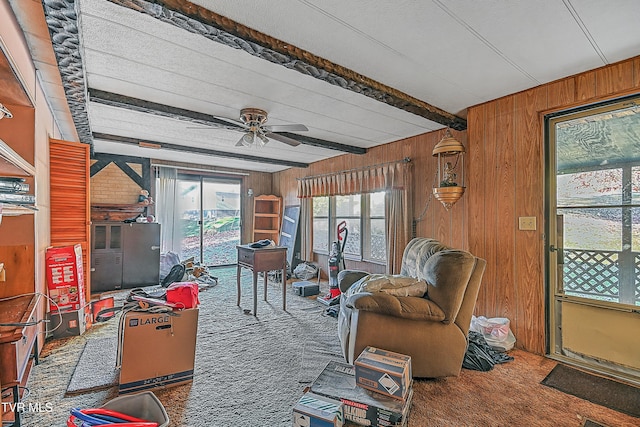 sunroom with ceiling fan and beam ceiling