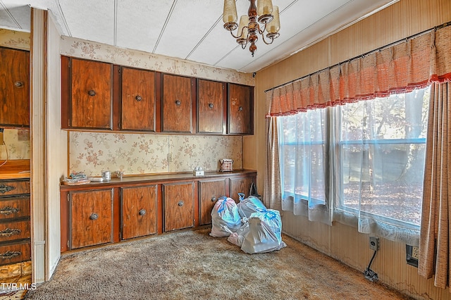 kitchen featuring light colored carpet, a textured ceiling, and an inviting chandelier