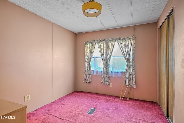 carpeted spare room featuring a textured ceiling