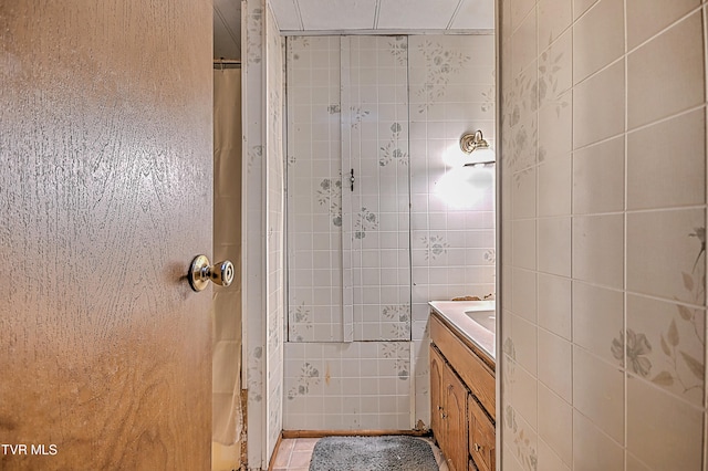 bathroom featuring tile walls, vanity, a shower with shower curtain, and tile patterned flooring