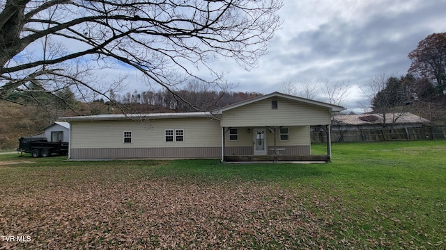 rear view of property featuring a yard