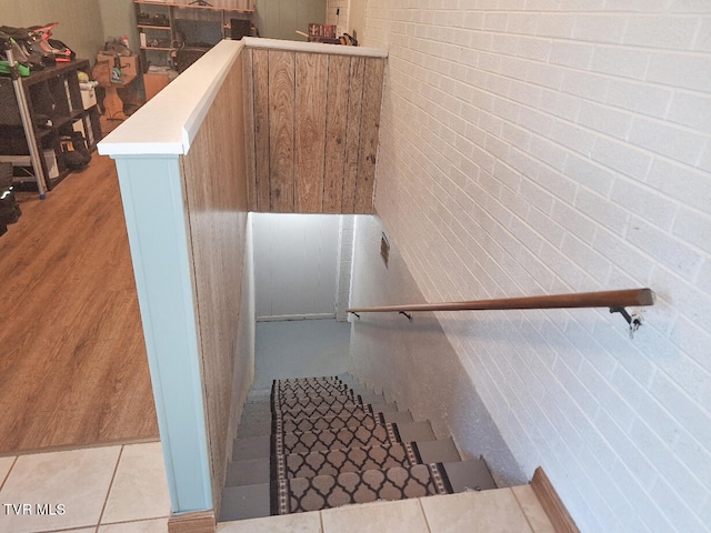 stairs with brick wall and tile patterned floors