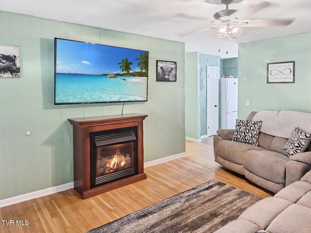 living room with light hardwood / wood-style flooring and ceiling fan