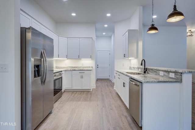 kitchen with stainless steel appliances, sink, pendant lighting, light hardwood / wood-style flooring, and white cabinetry