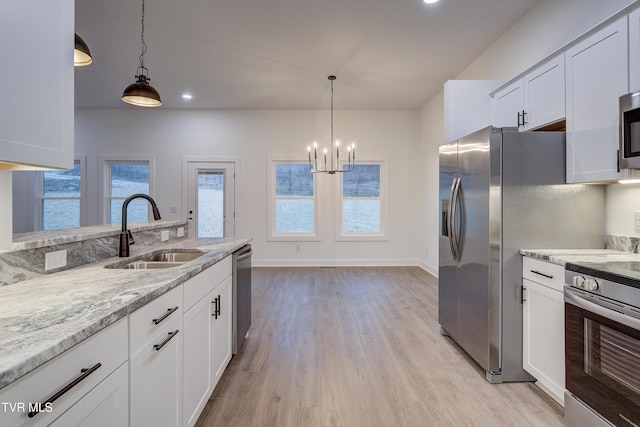 kitchen with light stone countertops, white cabinetry, sink, and appliances with stainless steel finishes